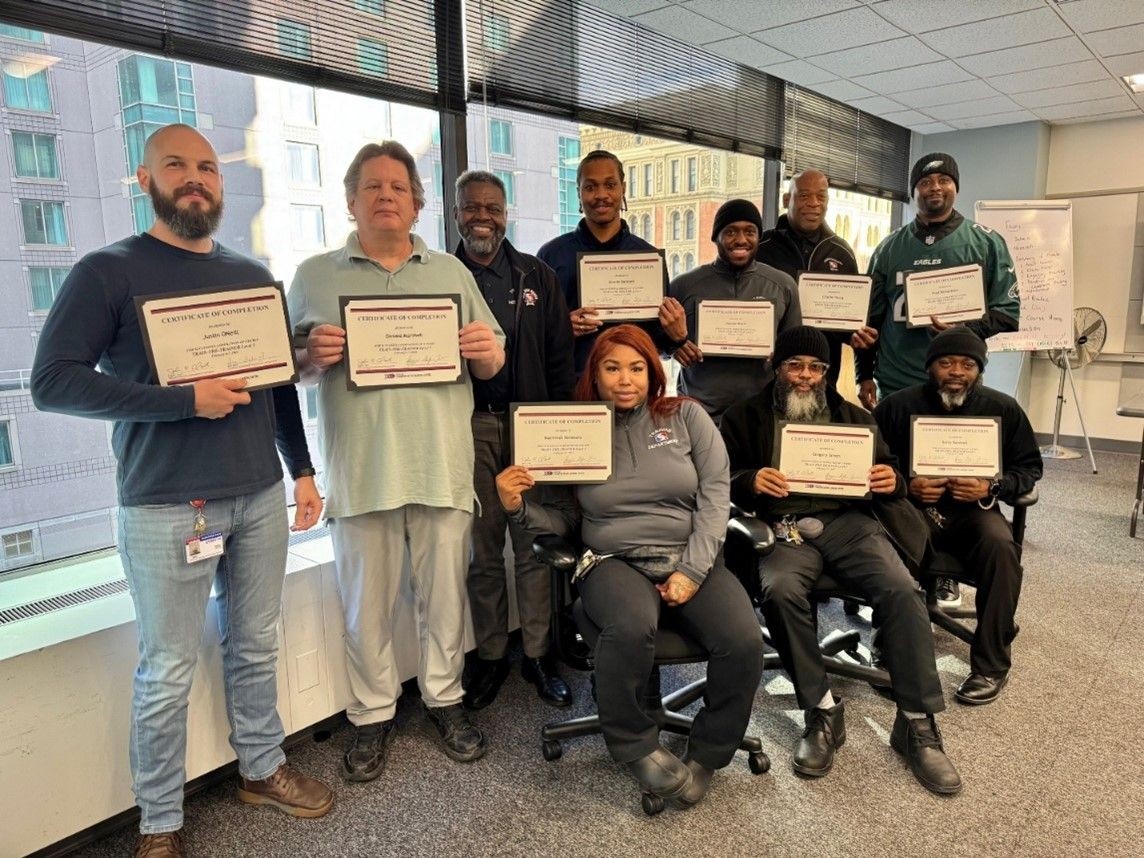 Level 1 Train-the-Trainer course participants and instructors posing with their certificates.