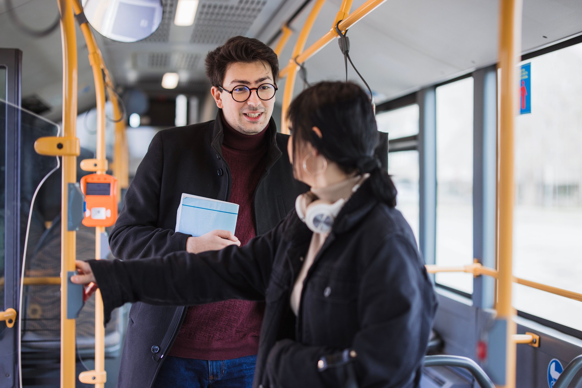 Couple of students talking in public transportation