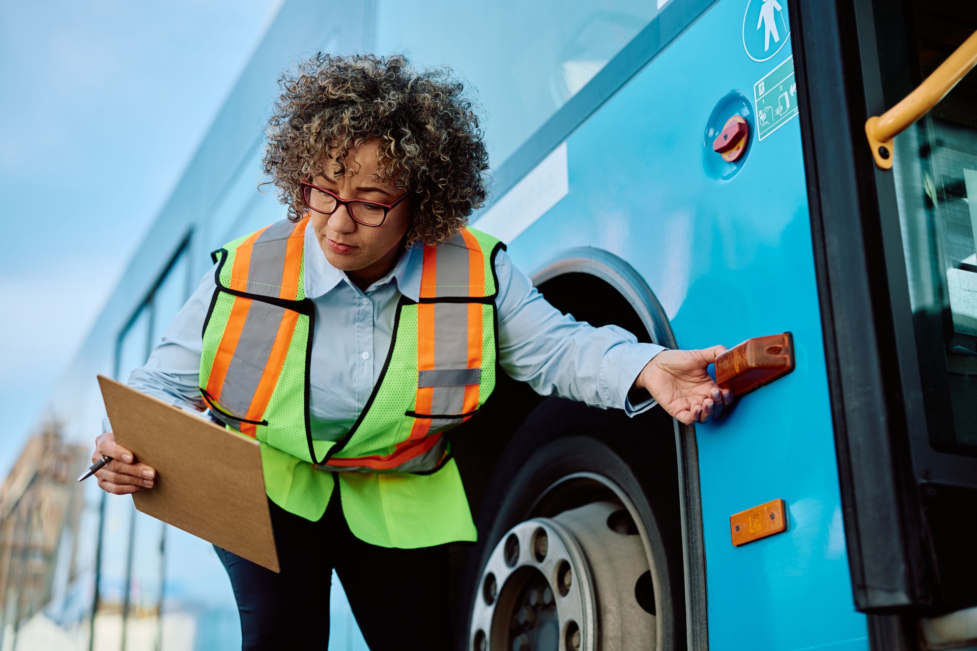 Female driver checking turn signal on a bus before the ride.
